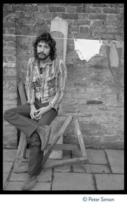 Cat Stevens: full-length portrait, seated by a laundry line on Carly Simon's patio