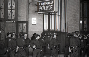 Police officers in riot gear waiting outside Cambridge Police station