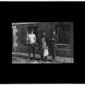 Three men in front of brick building