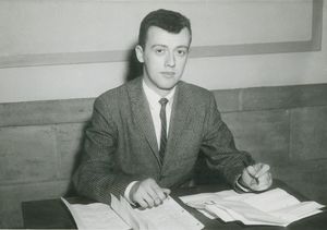 Suffolk University Professor John O'Callaghan (CAS) seated behind desk