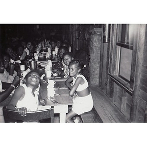 A group of young girls, seated in the dining hall of the Breezy Meadows Camp