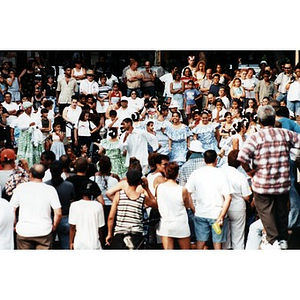 Young people performing a folk dance in front of a large crowd of spectators at Festival Betances.