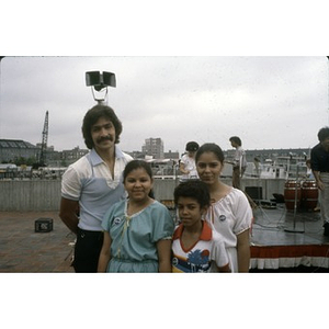 Man with three young performers prior to a performance given outside behind the New England Aquarium.