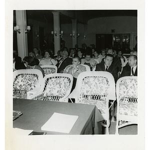 People seated in chairs at a Board of Overseers meeting