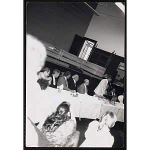 A male staffer speaking at the head table during a Boys' Club event