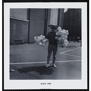 A man poses with two bunches of balloons on Tom Sawyer Day