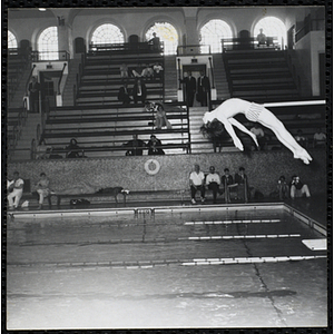 A boy performs a dive at a Boys' Club swimming championship