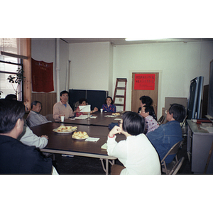 Association members hold a meeting around a table