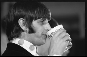 Ringo Starr drinking from a paper cup during a Beatles press conference