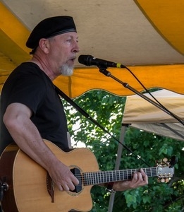 Richard Thompson: half-length portrait with guitar, singing, on stage at the Clearwater Festival