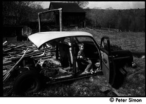 May Day at Packer Corners commune: child seated in a wrecked car