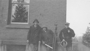 Student surveying group standing by a building