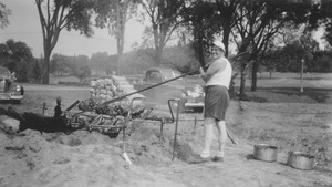 Warren McGuirk basting at a barbecue pit, summer session barbecue