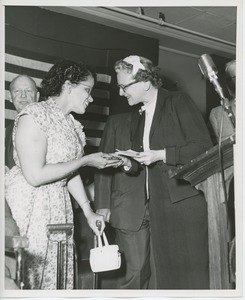 Unidentified woman handing gift to client at Institute Day