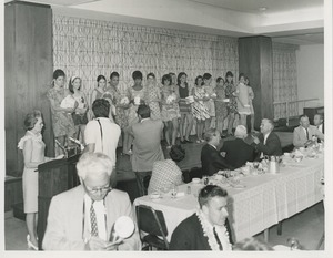 Women holding boxes on stage