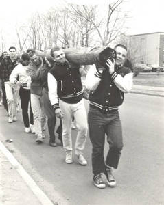 Students carrying a telephone pole during Work Week, 1969
