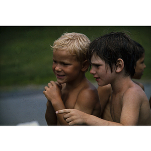 Boys standing together and conversing after swimming