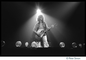 Jimmy Page (guitar) backlit with a spotlight on stage with Led Zeppelin during their Physical Graffiti tour