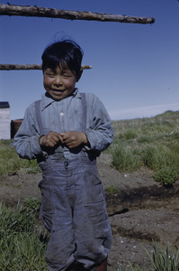 Young boy standing in front of drying racks