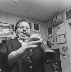 Walter Chesnut standing in office, playing horn
