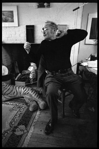 W. Eugene Smith, seated at a desk in his home