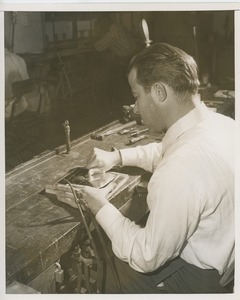 Man working on award plaque for Helen Keller