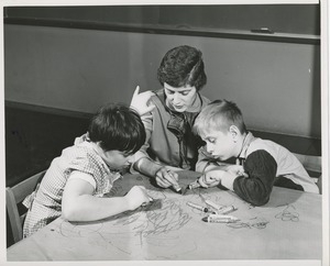 Unidentified woman drawing with two children with cerebral palsy