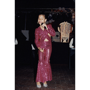 A girl in a sequined outfit sings and dances with a microphone for the Festival Puertorriqueño