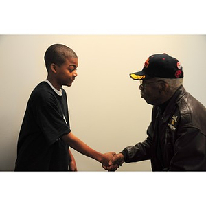 Willis D. Saunders Jr. shakes hands with a young African American boy