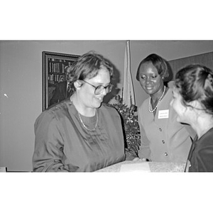 Three unidentified women at a ceremony in an office.