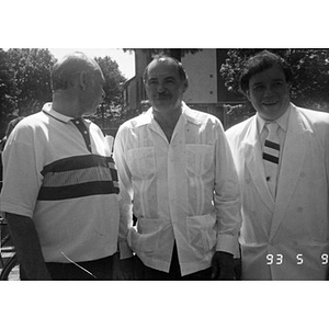Three unidentified men standing outside in the Villa Victoria neighborhood.