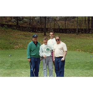 A four-man golf team posing on the golf course at a Boys and Girls Club Golf Tournament