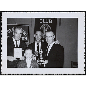 Three men and a boy posing with their awards at a Kiwanis Club's awards ceremony