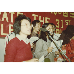 Chinese men and women singing at the 31st anniversary celebration of the People's Republic of China held at the Chinese Progressive Association headquarters