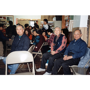 Chinese Progressive Association members sit waiting for a meeting to begin