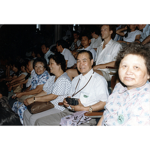 Audience member holds a camera at an event during a CPA tour of China