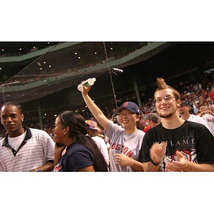 Four of the Torch Scholars at Fenway Park wave and cheer