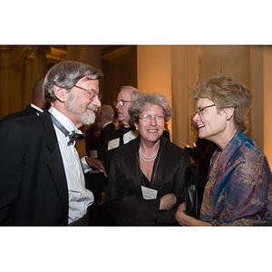 A man and two women converse at the Museum of Fine Arts