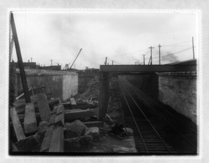 View of railroad tracks under a bridge, probably Dorchester Ave. bridge