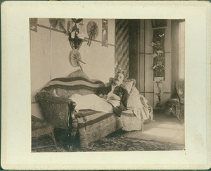 Unidentified man reclining on sofa while reading, Piazza, Castle Tucker, Wiscasset, Maine, undated