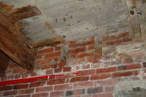 Interior view of brickwork and joists holding floor above; Cow Barn