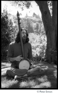 Krisha Das: portrait of the vocalist with Amazing Grace and member of the Ram Dass satsang, seated in a lotus position with an dotara