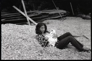 Nina Keller feeding her baby on a pile of woodchips, Montague Farm Commune