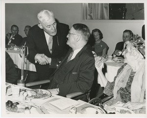 Hermann G. Place shaking hands with Dr. Louis Stevenson