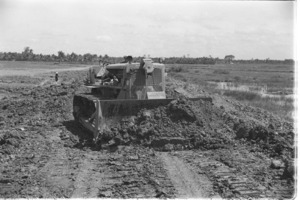 Clear and hold operation. Bulldozer repairing road sabotaged by Vietcong; Mekong Delta.