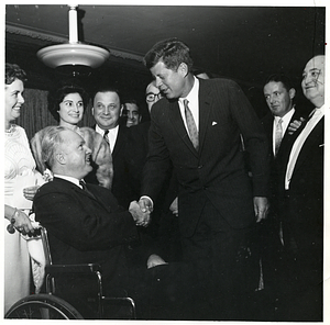 John F. Kennedy shaking the hand of Mayor John F. Collins with his wife Mary Collins at a formal occasion