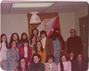 Group smiling in front of Portuguese Youth Group flag